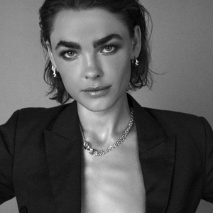 Detail of silver chain necklace and hoop earrings worn with a black blazer suit