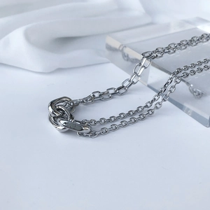 Detailed macro shot of silver double-layered chain necklace with interlocking metal rings