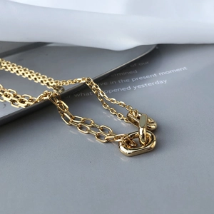 Detail view of double-layered gold chain necklace with interlocking geometric rings