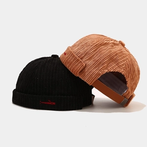 Corduroy brimless docker hats in black and yellow with fish embroidery and leather strap