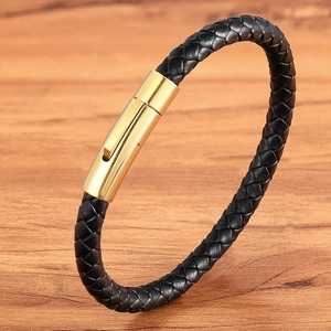 Braided black leather bracelet with a gold stainless steel magnetic clasp on wood surface
