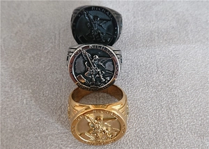 Detailed relief of Saint Michael on three stainless steel signet rings in gold black and silver
