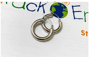 Close-up of polished silver hoop earrings in high-quality stainless steel texture