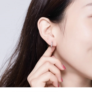 Close-up of minimalist S925 sterling silver hoop earrings with sparkling zircon on earlobe