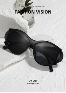Artistic close-up of punk style matte black sunglasses resting on a white stone texture