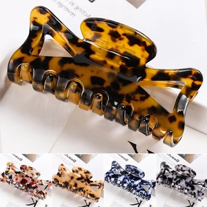 Close-up of a large tortoiseshell hair claw clip with multiple color variants shown below