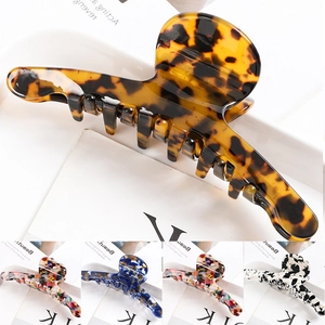 Detail of large metal hair claw clips in tortoise shell, mosaic, and cow patterns