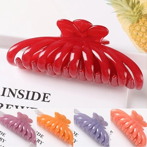 Detail of large metal claw clips in red, purple and orange with glossy finish