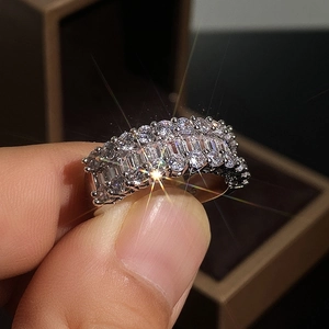 Gros plan macro de zircons taille baguette et ronde sur une bague plaquée or blanc