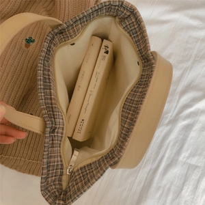 Close-up of the vintage plaid handbag interior showing spacious capacity with books