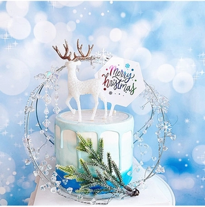 Détail d'un renne blanc scintillant et d'un cake topper Merry Christmas avec perles