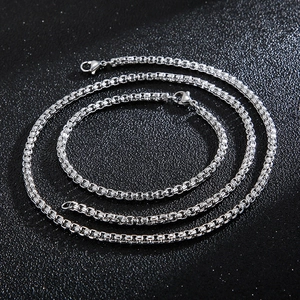 Minimalist silver stainless steel box chain necklace for men on a black textured background