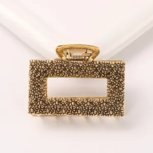 Detail of vintage gold alloy hair claw clip featuring caviar embossed hollow rectangular design