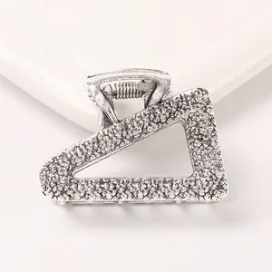 Detail view of antique silver geometric hair claw clip with rock texture surface