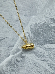 Vue détaillée du collier hip-hop doré avec pendentif cacahuète et perle blanche