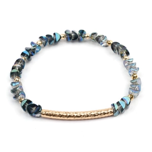 Detail of blue iridescent crystal beads and gold hammered tube on geometric bracelet
