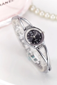 Detail of silver quartz watch with black rhinestone dial and metal bangle strap