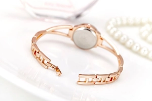 Macro detail of rose gold bracelet watch case back showing smooth metallic finish