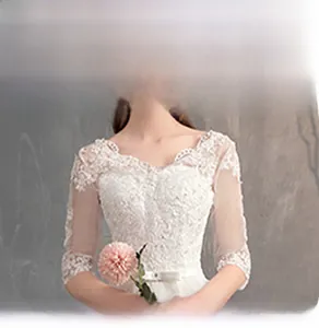 Primo piano dell'abito da sposa in pizzo bianco con scollo a barchetta e ricami floreali
