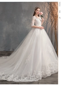 Vista dettagliata dei ricami in pizzo floreale sull'abito da sposa con maniche lunghe