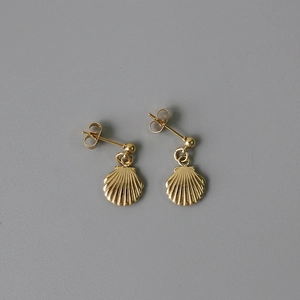 Detailed macro view of 14K gold-plated starfish and shell stud earrings on a dark base
