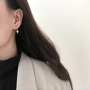 Close-up of model wearing small 14K gold plated starfish stud earring in matte finish