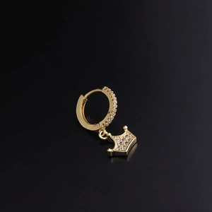 Detailed view of a gold huggie hoop earring with a sparkling zircon crown pendant