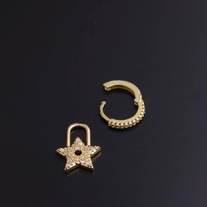 Detail of gold geometric hoop earrings with star-shaped charm and zircon inlay