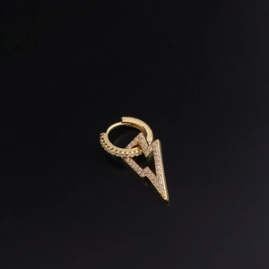 Detailed view of golden lightning bolt earring with micro-pave cubic zirconia on black background