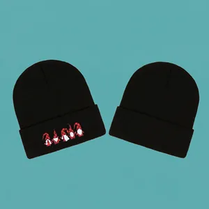 Black knitted winter beanie hat set with festive gnome embroidery on warm acrylic fabric