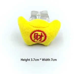 Détail de lingot d'or en peluche jaune avec broderie de richesse, taille 7x3,7 cm