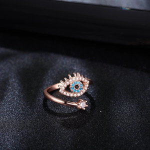 Detalle de anillo ojo turco oro rosa con piedras azules y cristales resplandecientes