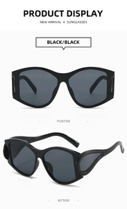 Front and 45-degree views of black punk-style oversized sunglasses with wavy frames