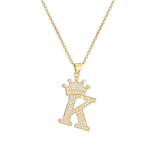 Detailed close-up of a gold-plated necklace with a crystal-encrusted crown and letter K