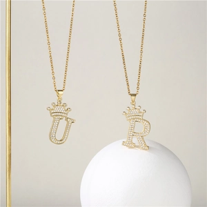 Macro view of gold plated crown initial necklaces U and R with micro-paved zircons