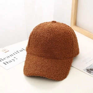 Detailed texture of brown teddy fleece baseball cap on a clean white surface