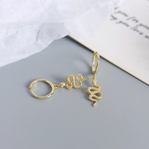 Detailed view of gold snake earrings with textured scales and luxury hoop design