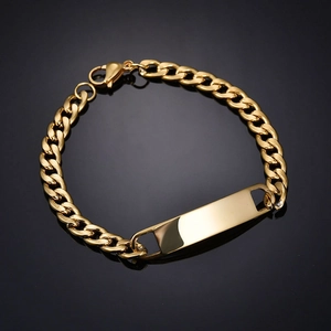 Polished gold curb chain bracelet with curved engravable rectangular bar on black surface
