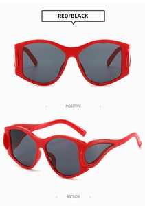Red punk style oversized sunglasses with wavy frames and dark grey lenses detail