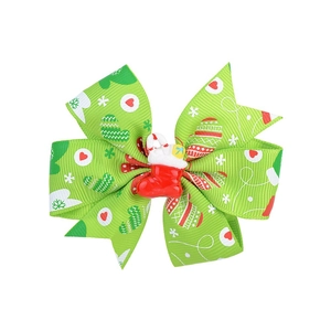 Green Christmas ribbon bow hair clip with Santa Claus figurine and festive holiday patterns