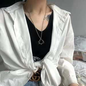 Detail of geometric silver triangle and star pendant necklace worn with casual outfit