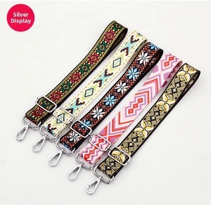 Detail of silver hardware and five bohemian patterned jacquard bag straps on white backdrop