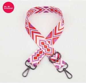 Close-up of adjustable woven bag strap with geometric patterns and gunmetal hardware