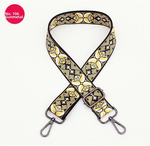 Detail of adjustable woven bag strap with gunmetal hardware and geometric floral pattern