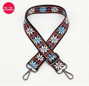 Detail of bohemian style jacquard bag strap with floral pattern and gunmetal buckle