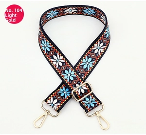 Detailed view of bohemian style woven bag strap with light gold metal swivel hooks