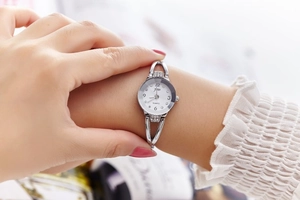 Detail of silver ladies bracelet watch with white dial and crystal accents on wrist