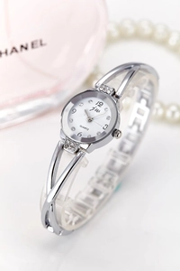 Detail of silver bangle watch with rhinestones and white dial on an elegant background