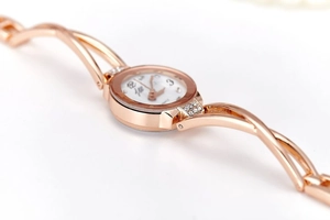 Detailed view of rose gold women's watch with twisted metal band and crystal accents