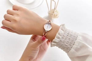 Elegant rose gold rhinestone bracelet watch for women with white dial worn by a model
